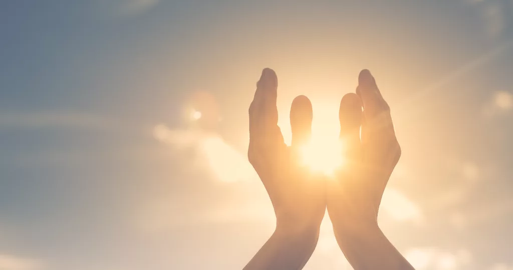 persons hands around the sun